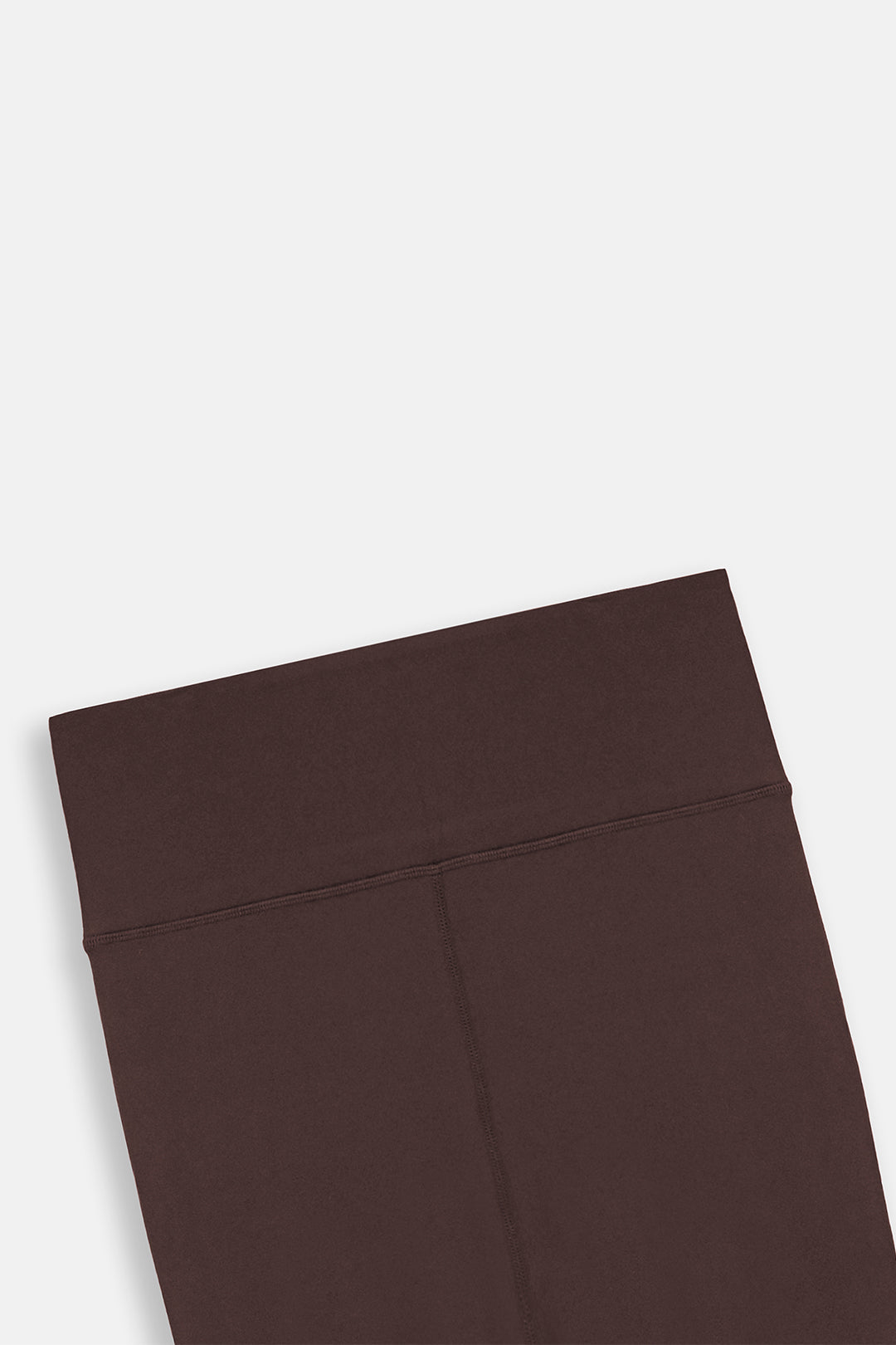Image of A close-up of dark brown leggings showing the waistband and upper leg area, photographed on a clean white background.