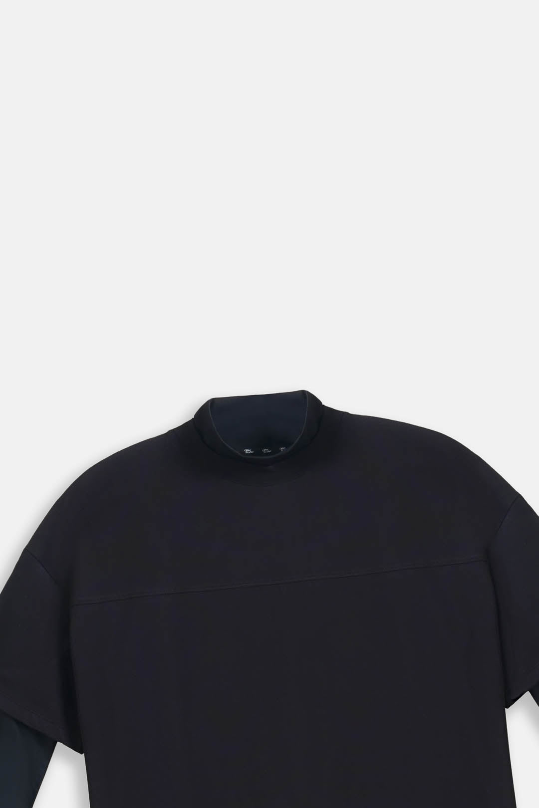 A close-up of a black short-sleeve mock neck top, showing the collar and upper chest area against a light gray background.